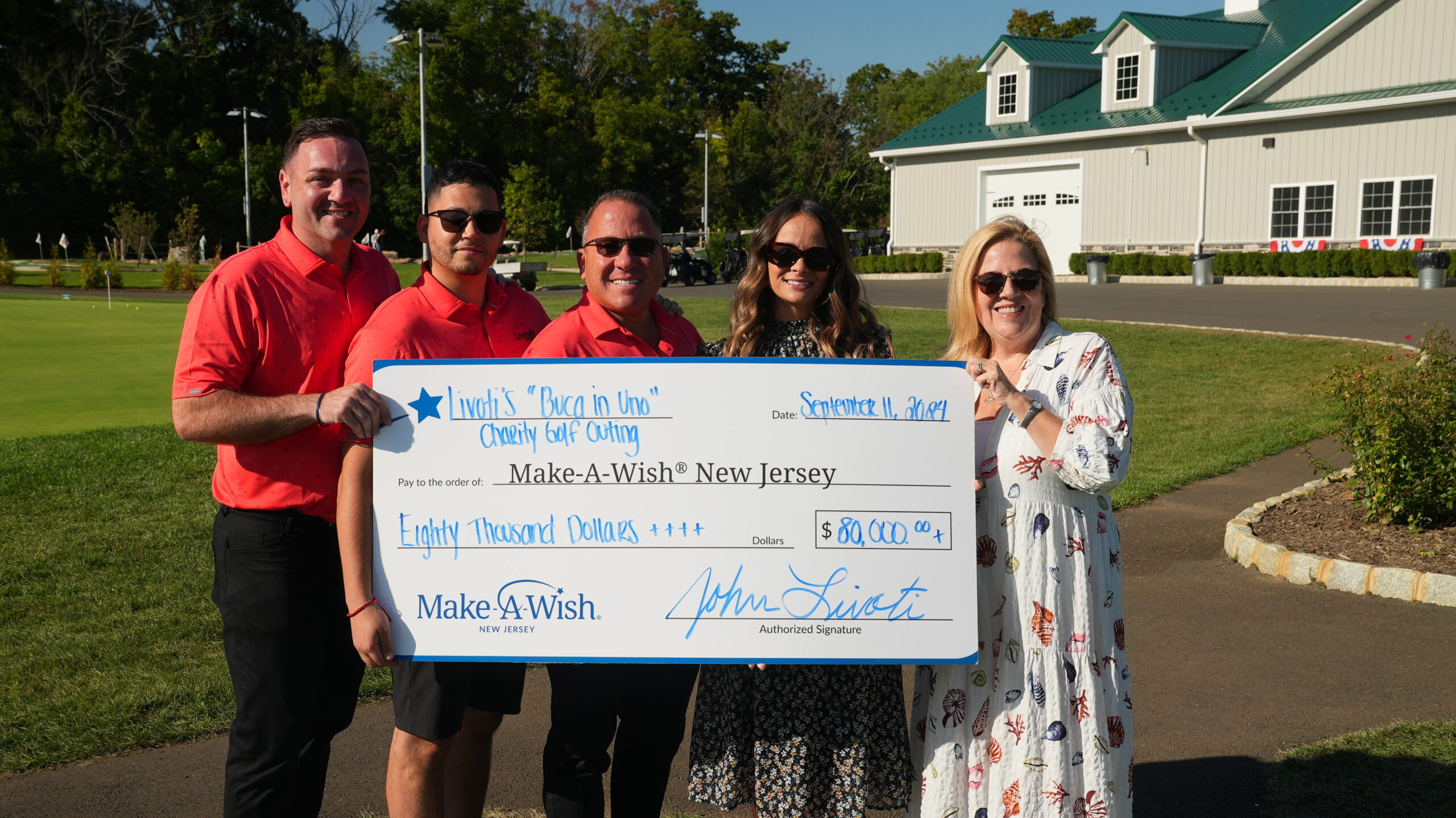 Livoti's Old World Market family holding a large check written out to the Make-A-Wish Foundation of New Jersey